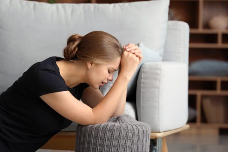 a woman holding her head. How To Overcome Anxiety In 12 Best Ways Possible