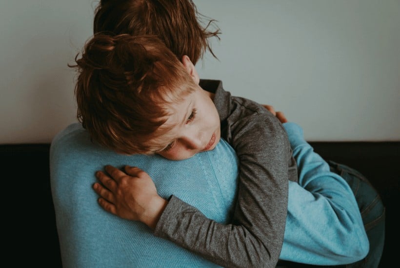 an image of a little boy being held and comforted featured image for 7 Ways of Coping With Loss and Grief
