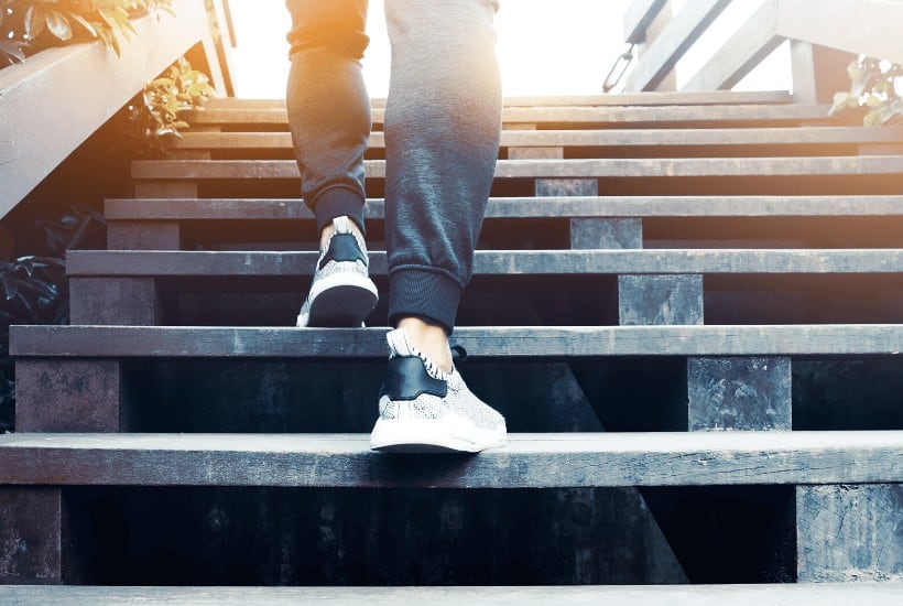 an image of a woman walking up a flight of steps. featured image for 5 Steps for Setting Spiritual Goals That Work in 2020