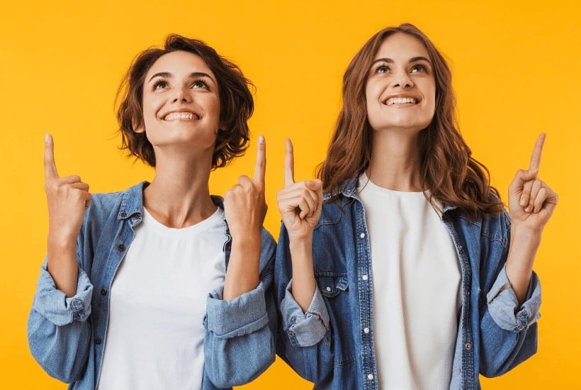 an image of two women standing beside one another with both index fingers pointing upward with text reading Are You Making a Difference in Someone's Life?