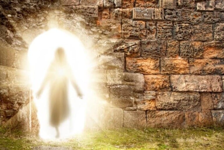 an image of Jesus walking from a stone tomb through a bright golden light featured image for The Resurrection of Jesus: What Does This Actually Mean for You?