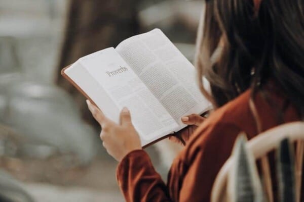 a woman sitting reading the bible featured image for Bible Study