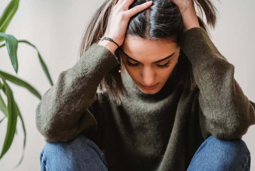 a woman holding her head Beating Anxiety Worksheets